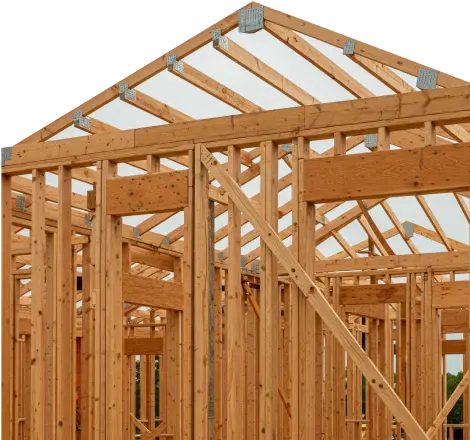 Wooden house frame under construction with clear sky background.