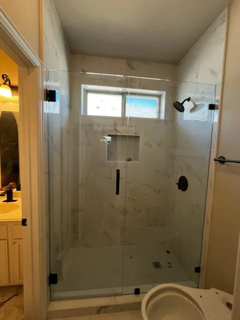 Modern bathroom with white tiles, freestanding tub, glass shower, and vanity mirror.