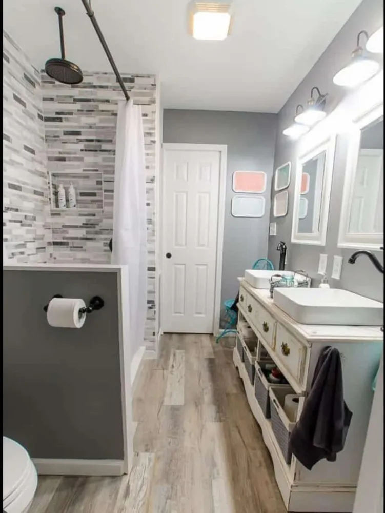 Modern bathroom with white tiles, freestanding tub, glass shower, and vanity mirror.