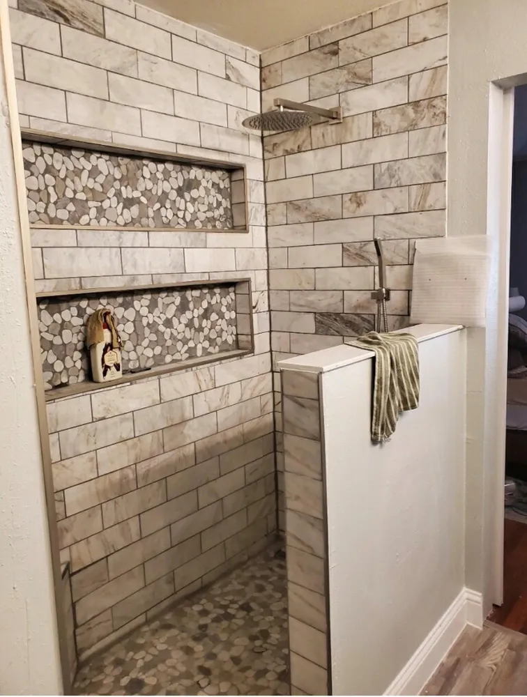 Modern bathroom with white tiles, freestanding tub, glass shower, and vanity mirror.